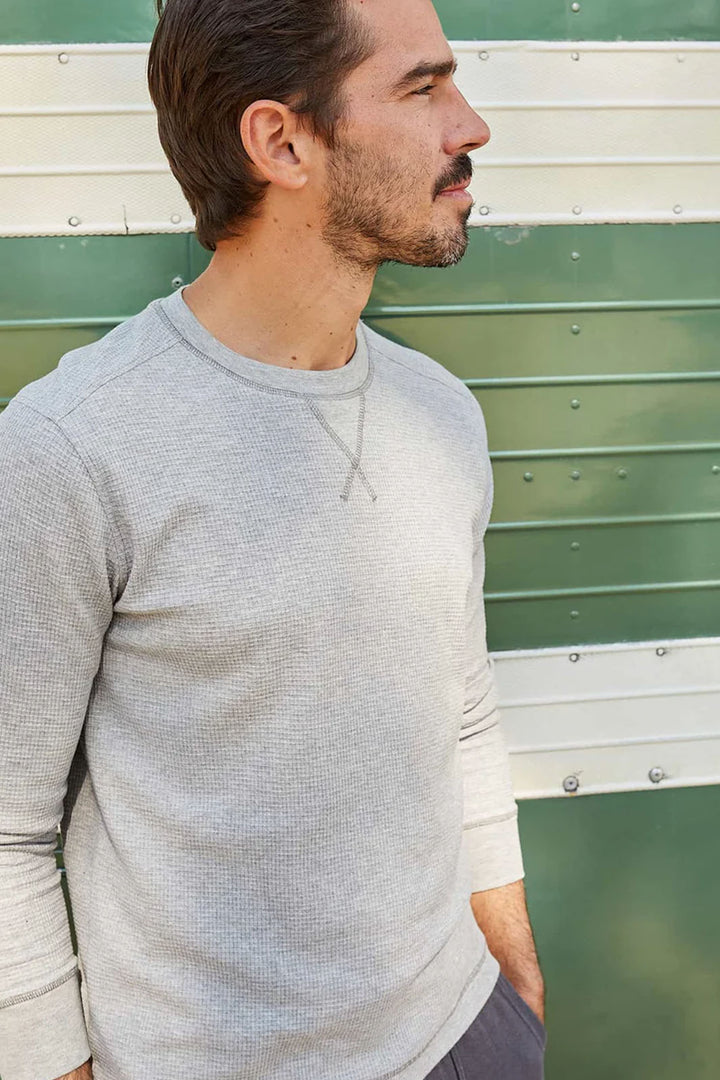 Up close view of a man wearing grey heather long sleeve henley
