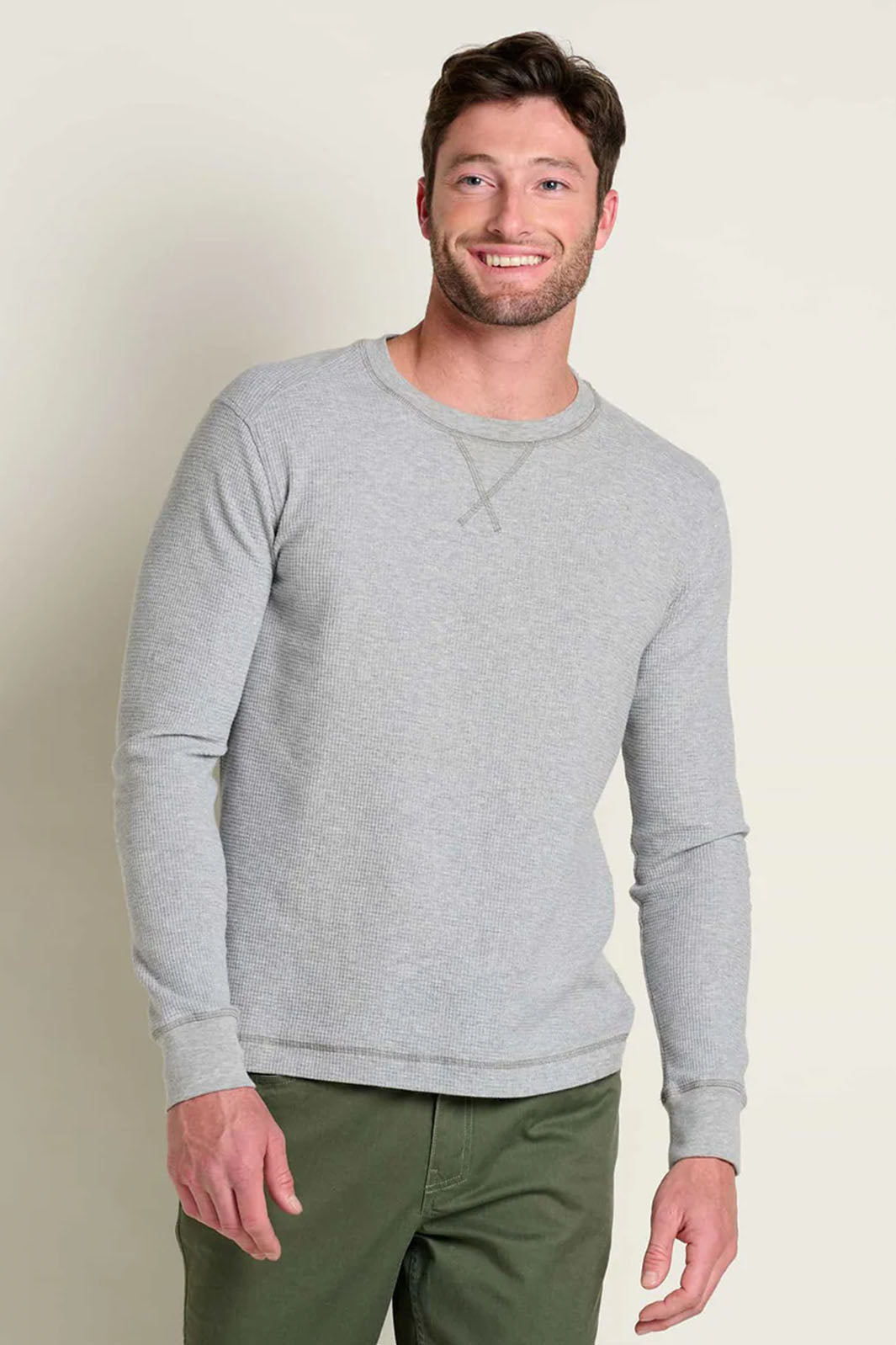 Smiling man wearing a grey heather henley shirt. 