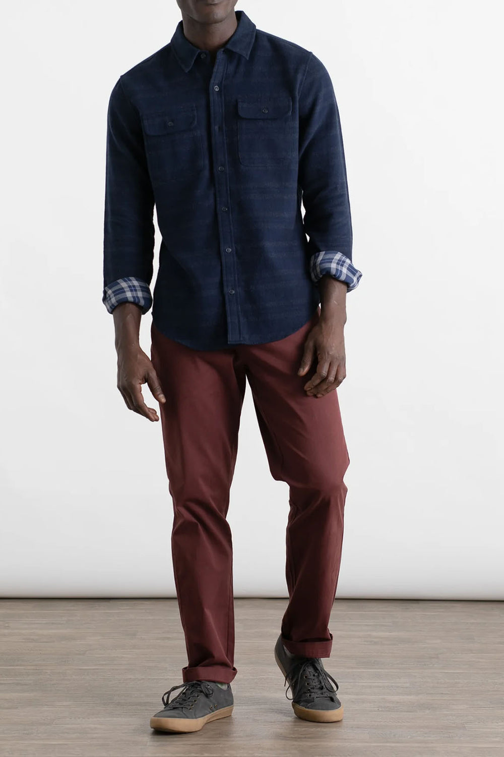 Man wearing burgundy polk chino pants with a button down. 