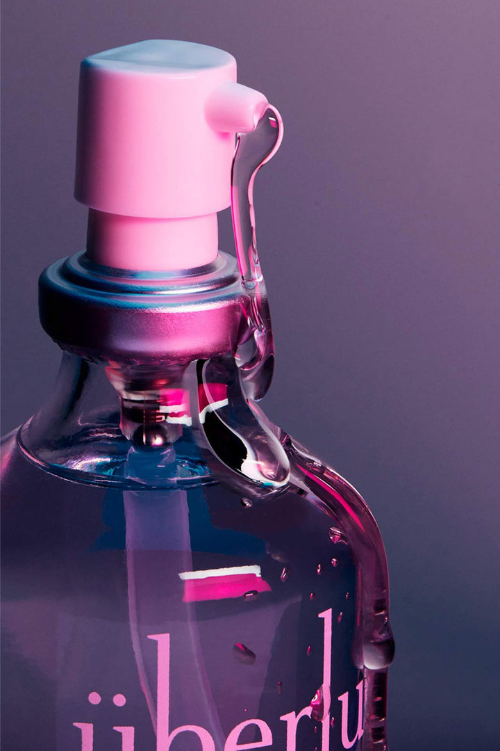 Close up of Chicago made silicone personal lubricant for sex, style, or sport. White pump on glass bottle with neon lights. 